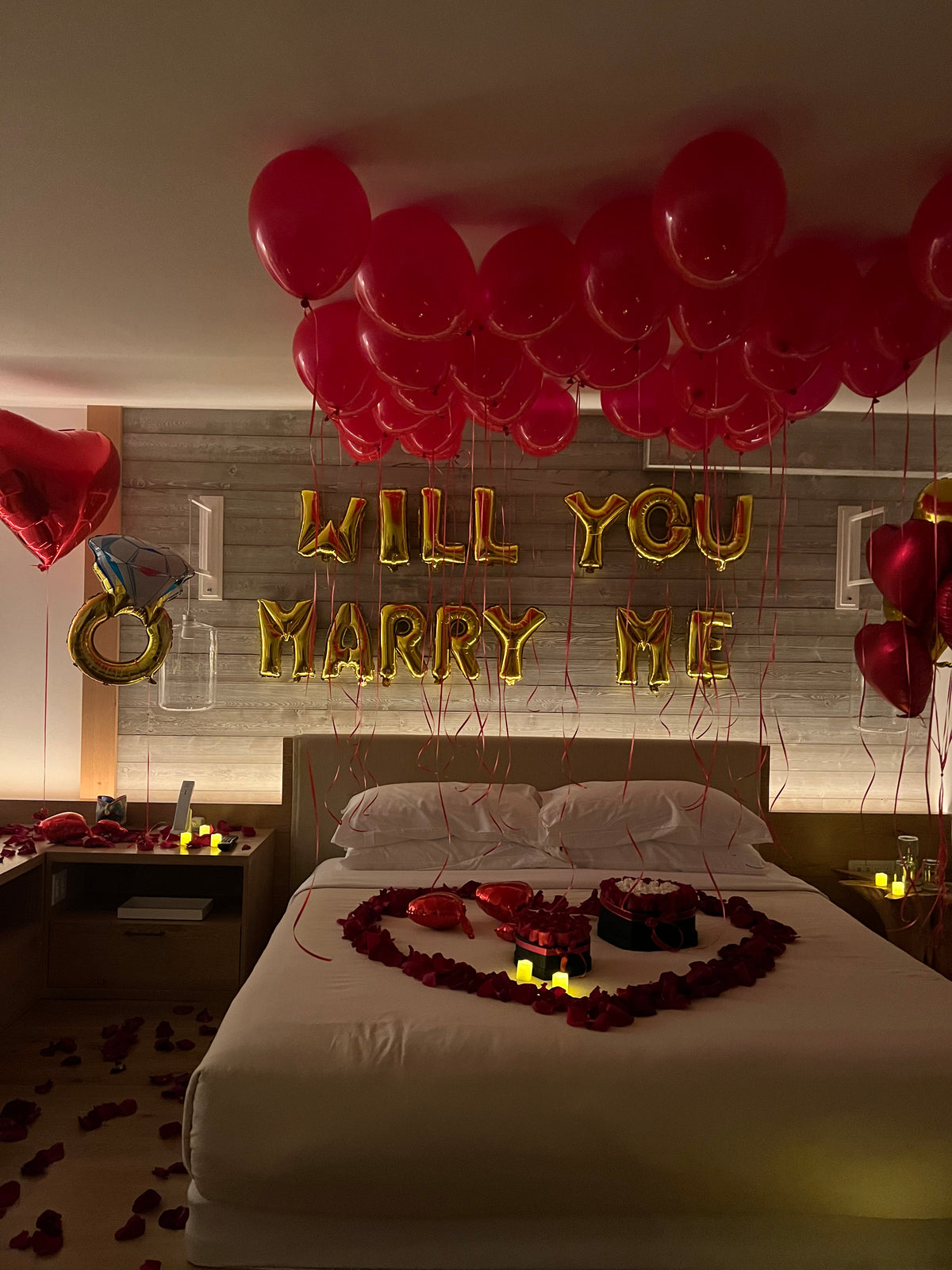 Hotel proposal setup in Miami with roses, balloons, candles and romantic room decor