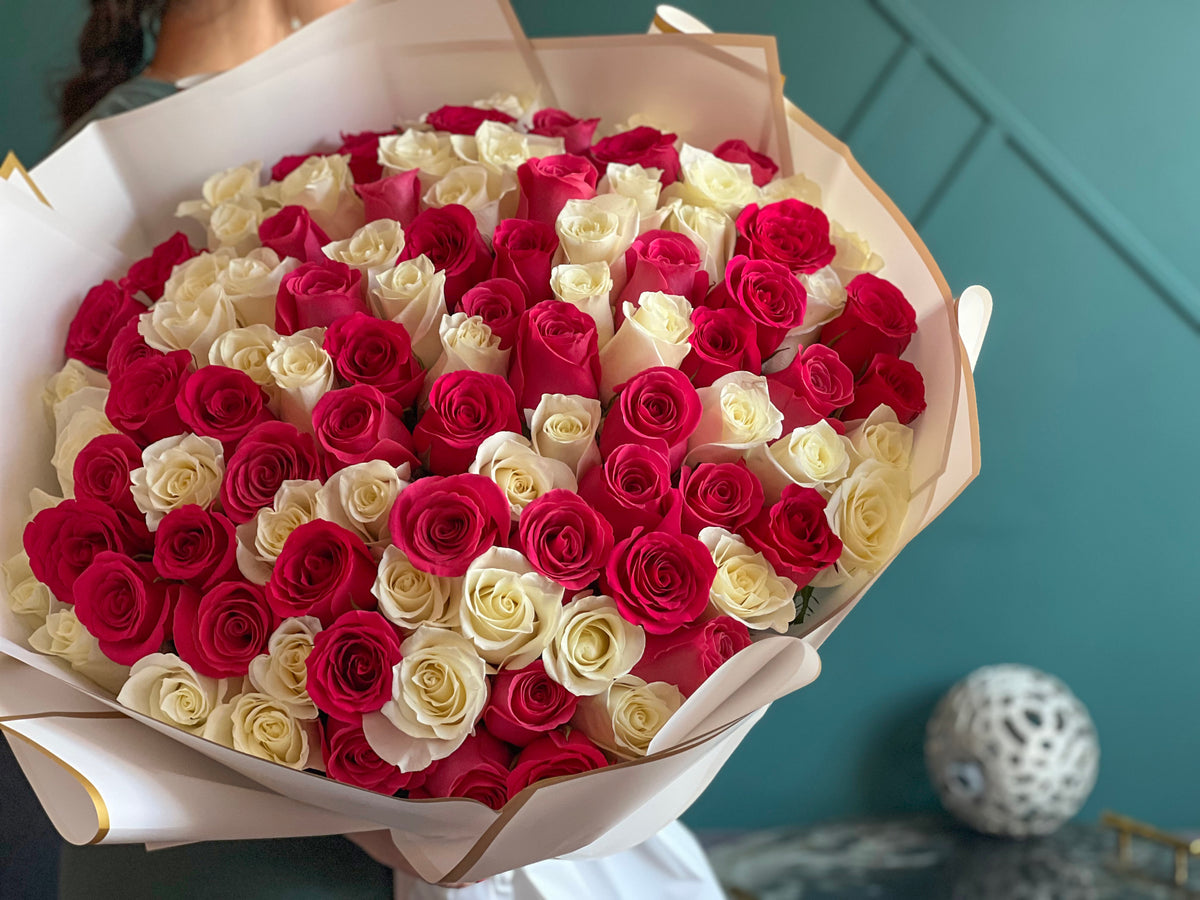 100 hot pink and white roses in large hand tied bouquet