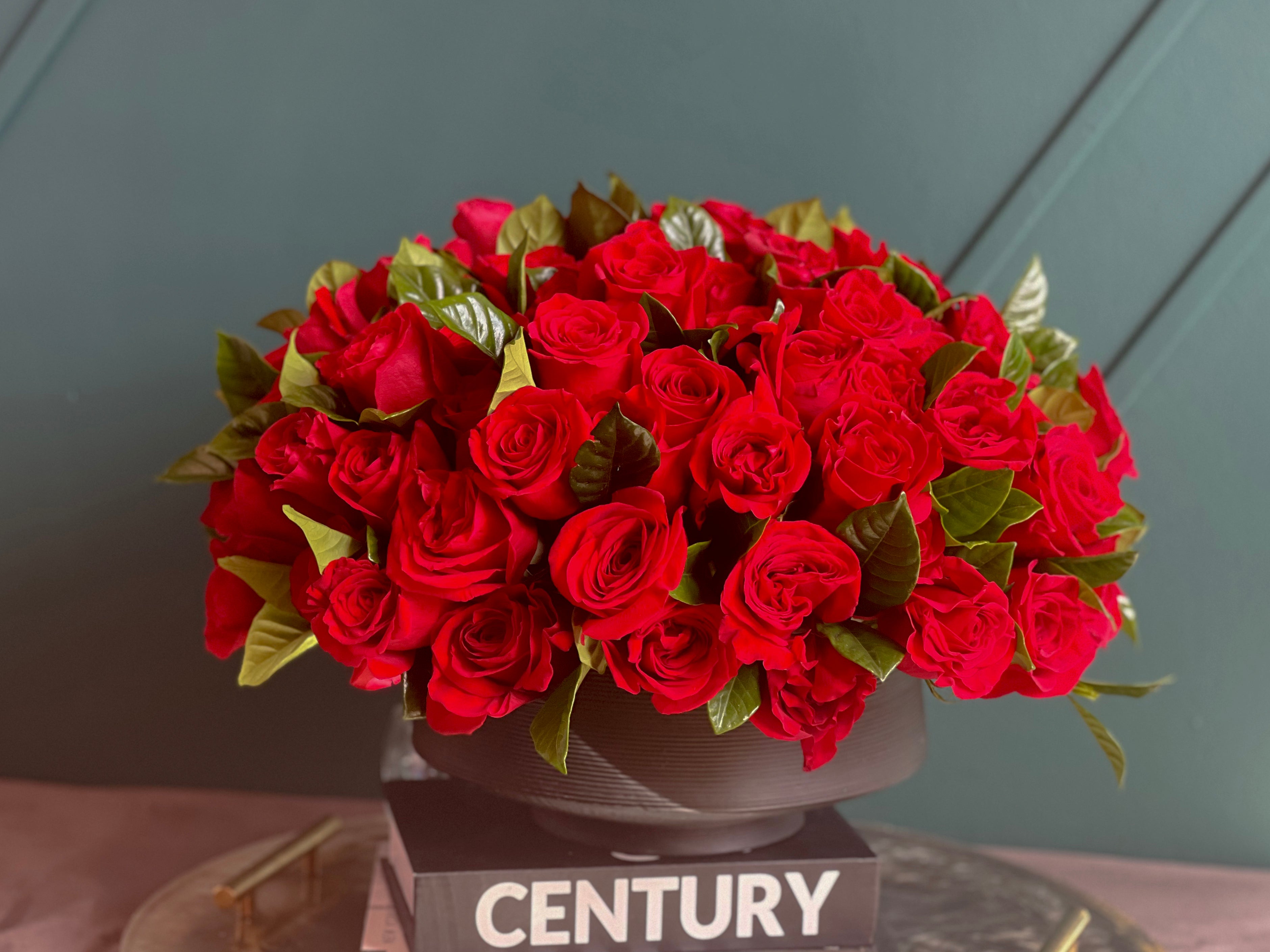 100 premium red roses with greenery in vase