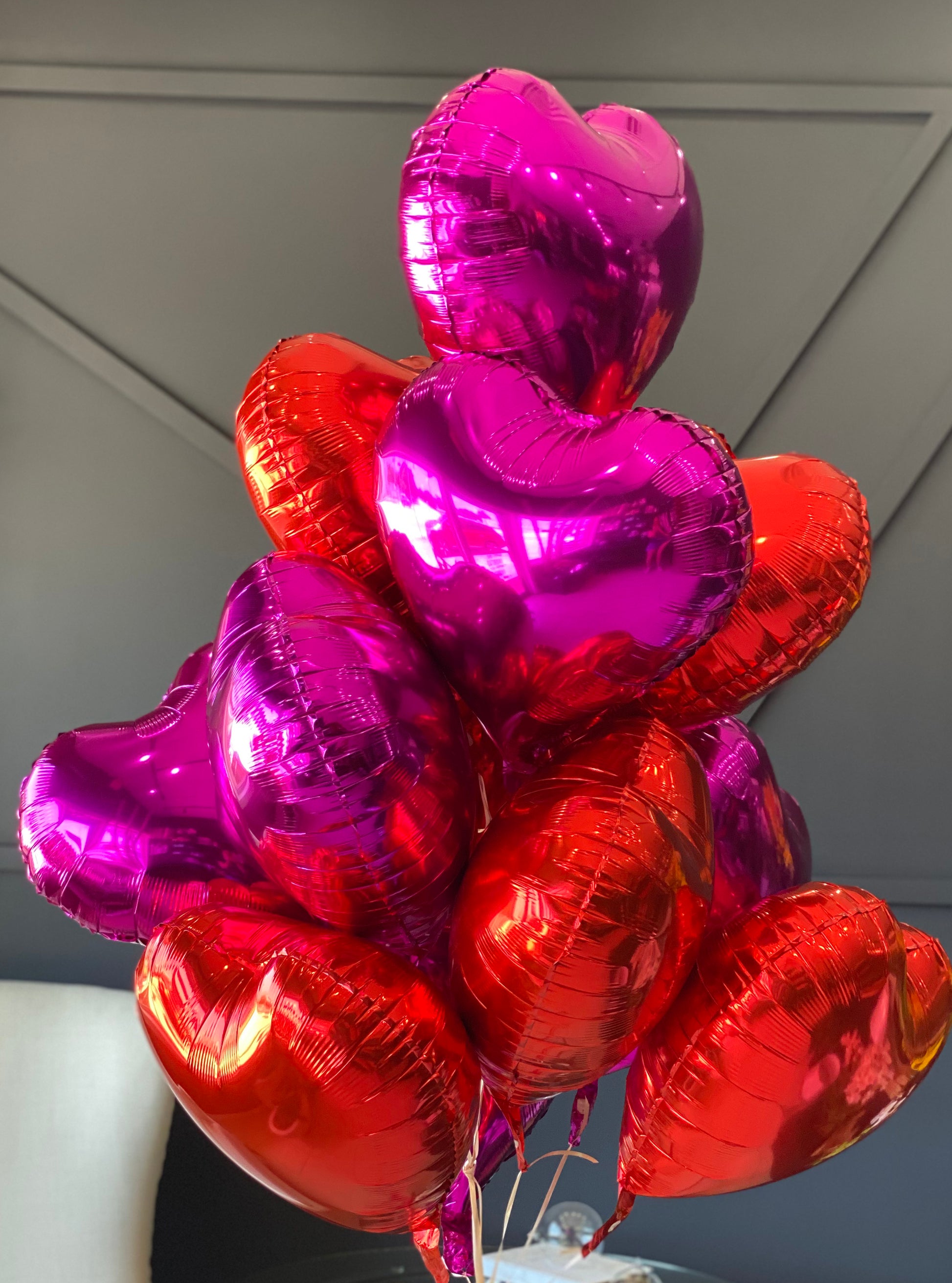 12 red and hot pink heart balloons arranged by Luxury Flowers Miami