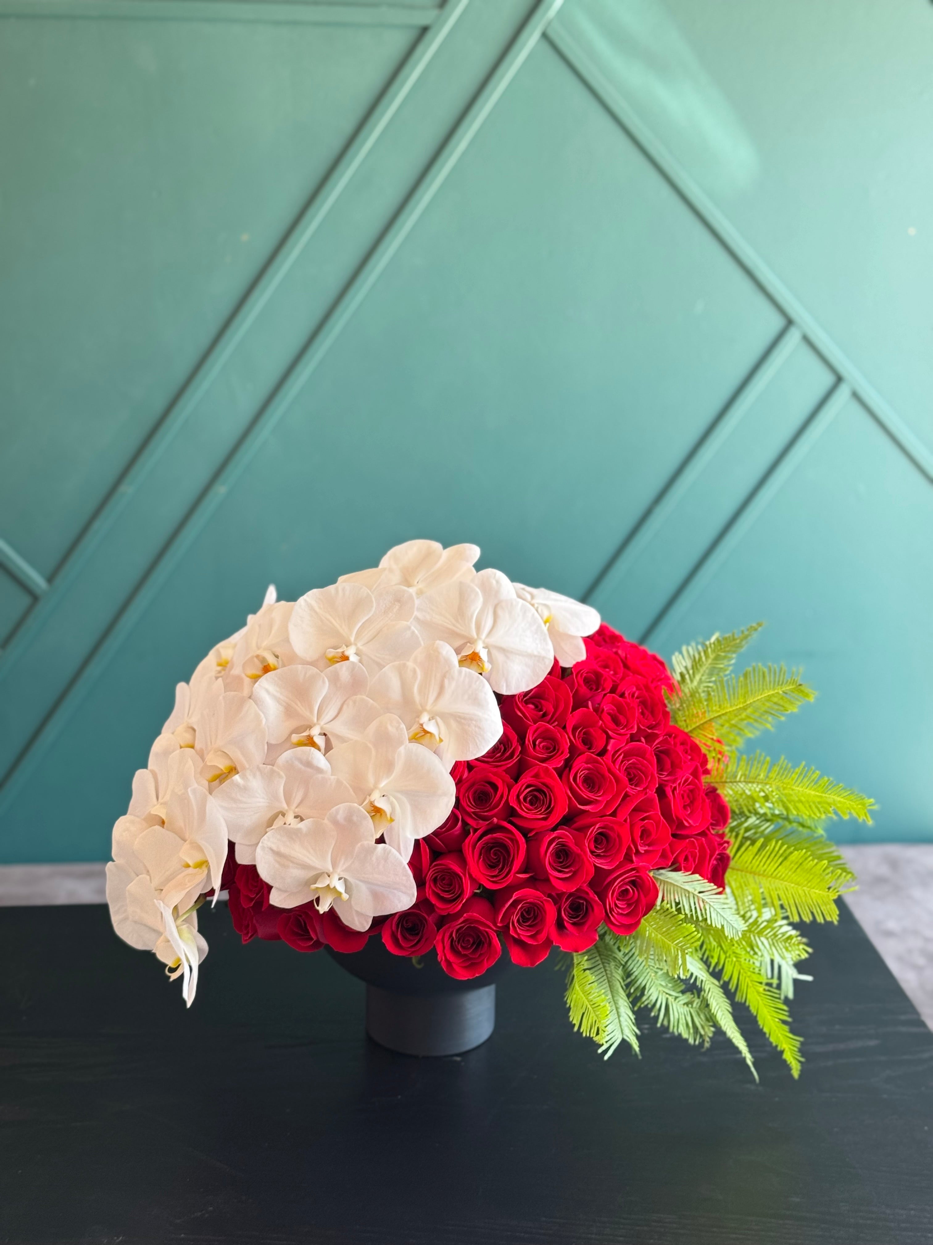 150 premium red roses with cascading white orchids in black vase