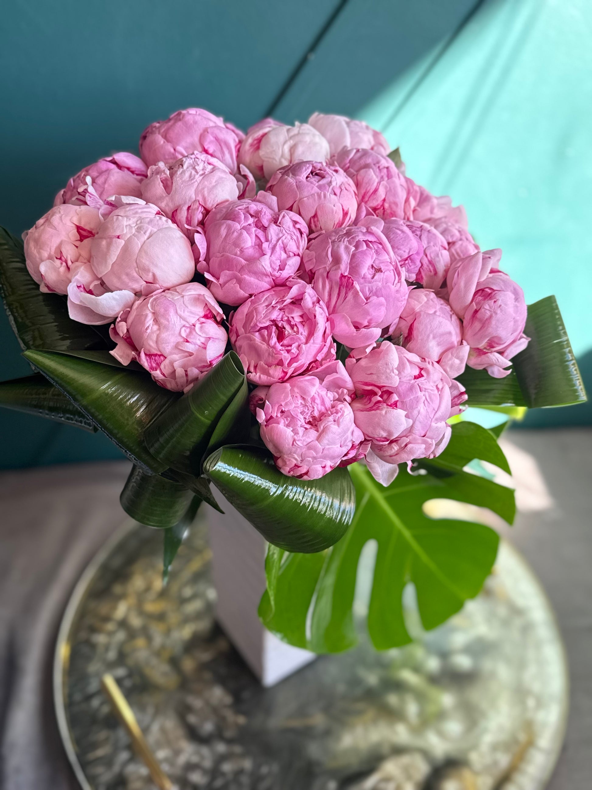24 premium pink peonies handcrafted in a contemporary vase
