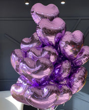 24 purple heart-shaped balloons arranged by Luxury Flowers Miami