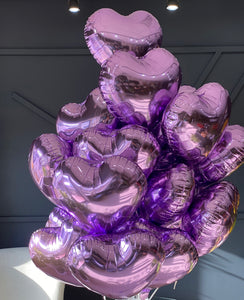 24 purple heart-shaped balloons arranged by Luxury Flowers Miami