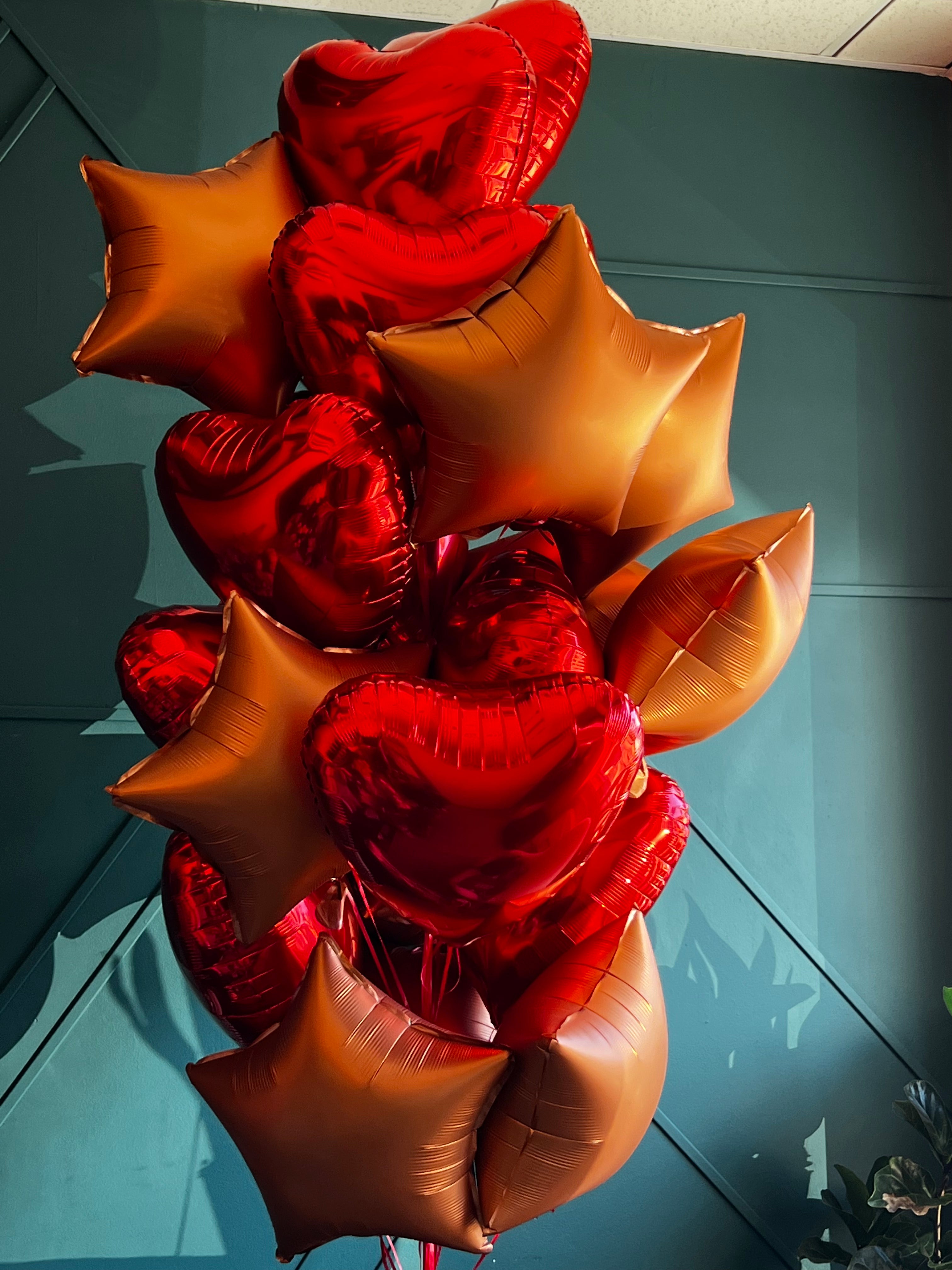 24 red and bronze foil balloons arranged by Luxury Flowers Miami