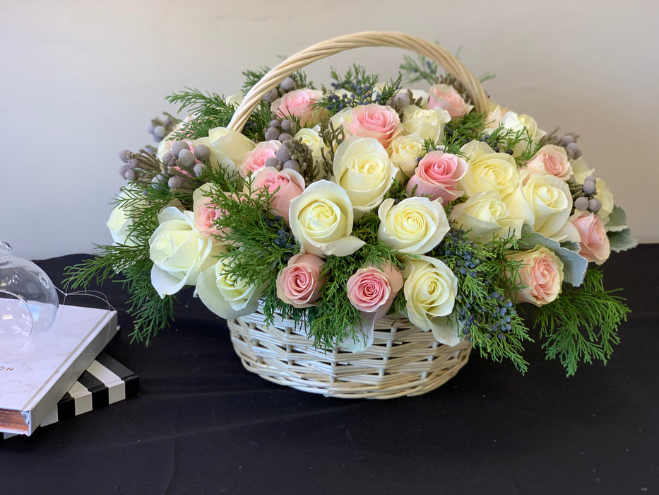 Wooden basket with roses and Christmas greenery
