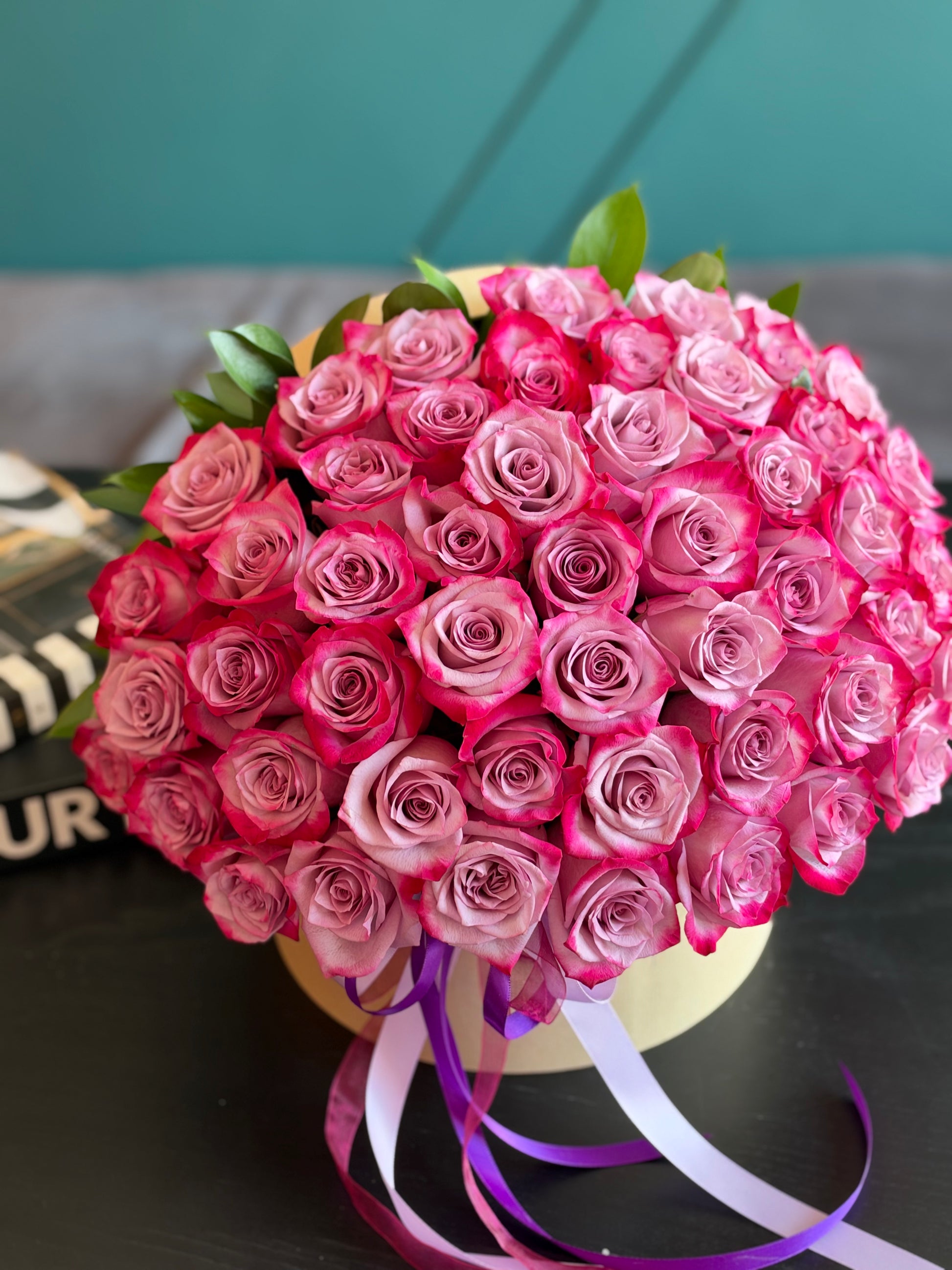 50 deep purple roses with decorative ribbons in a flower box