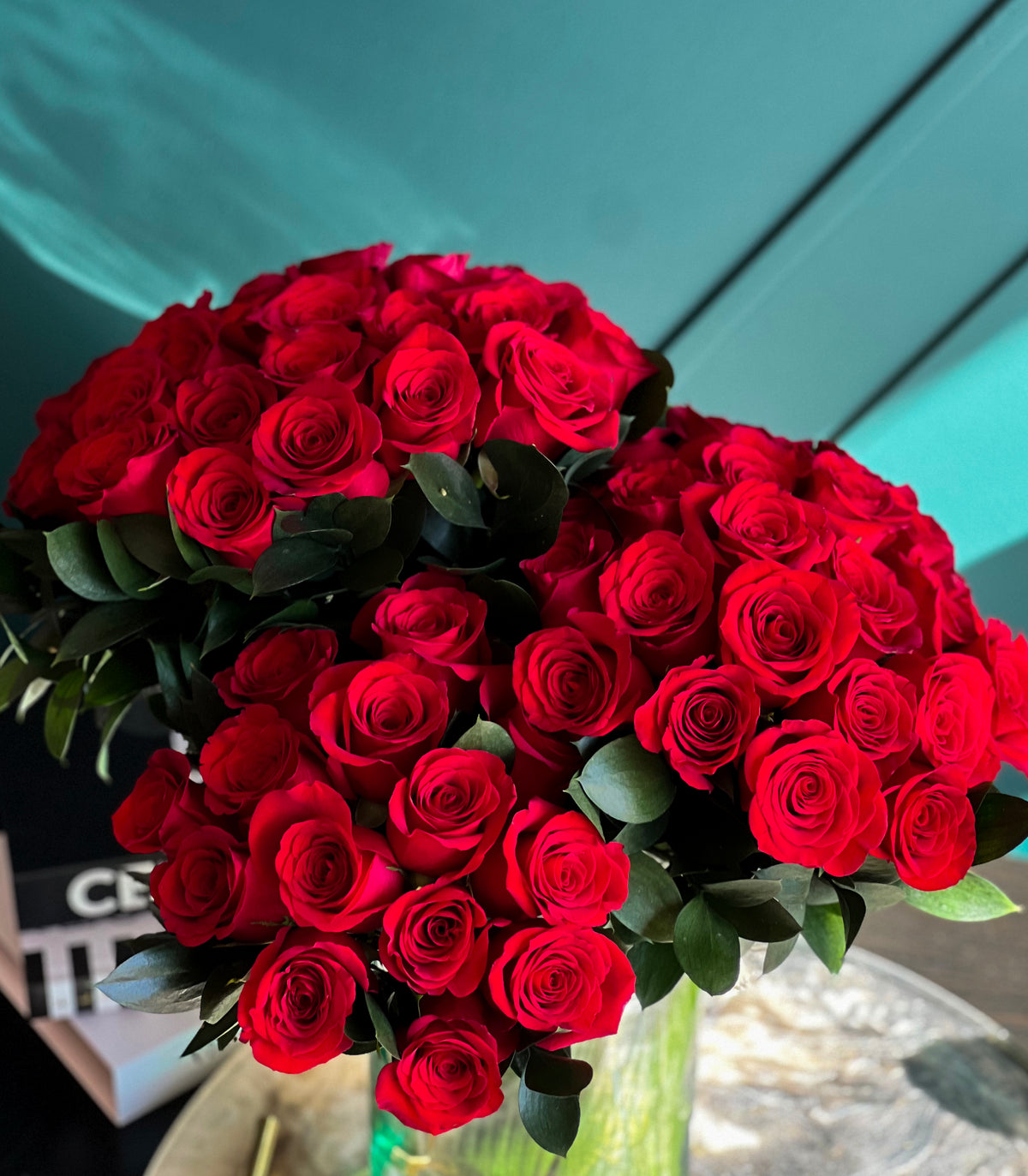 72 premium red roses arranged in a glass vase