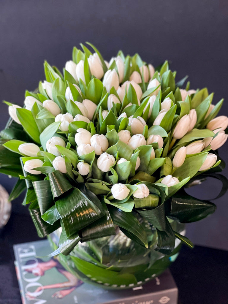 75 white tulips arrangement in glass fishbowl vase