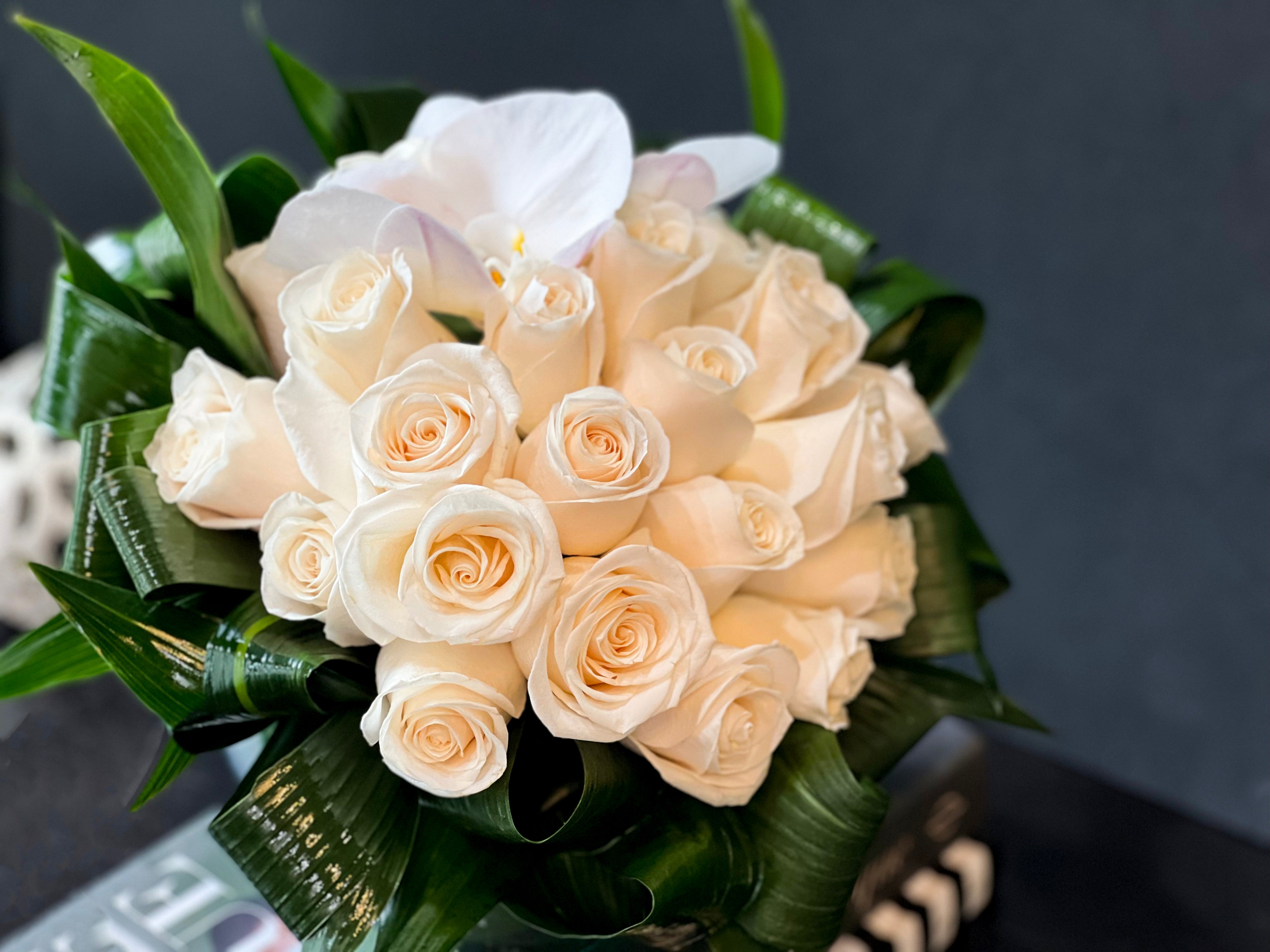 Beautiful 24 white roses arranged in a compact fishbowl centerpiece