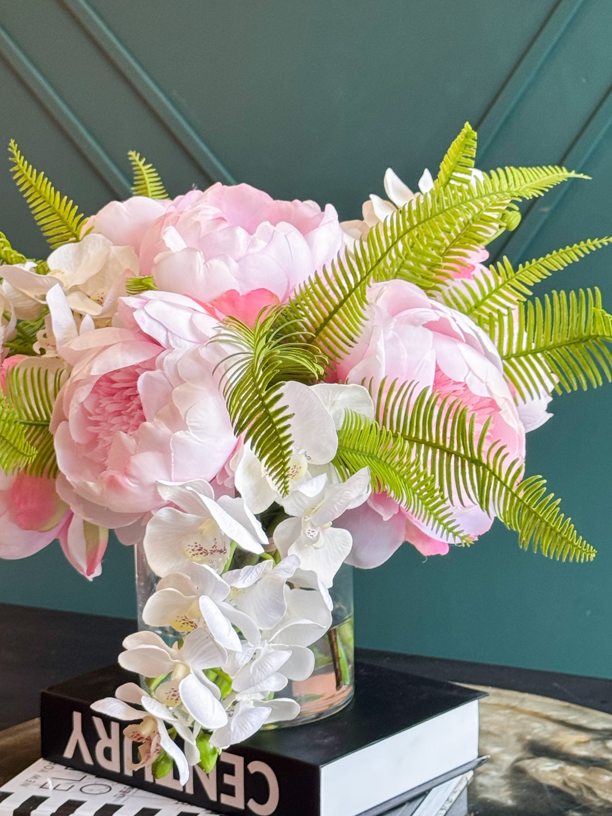 Beautiful faux floral centerpiece with pink peonies and cascading white orchids in a modern glass vase.