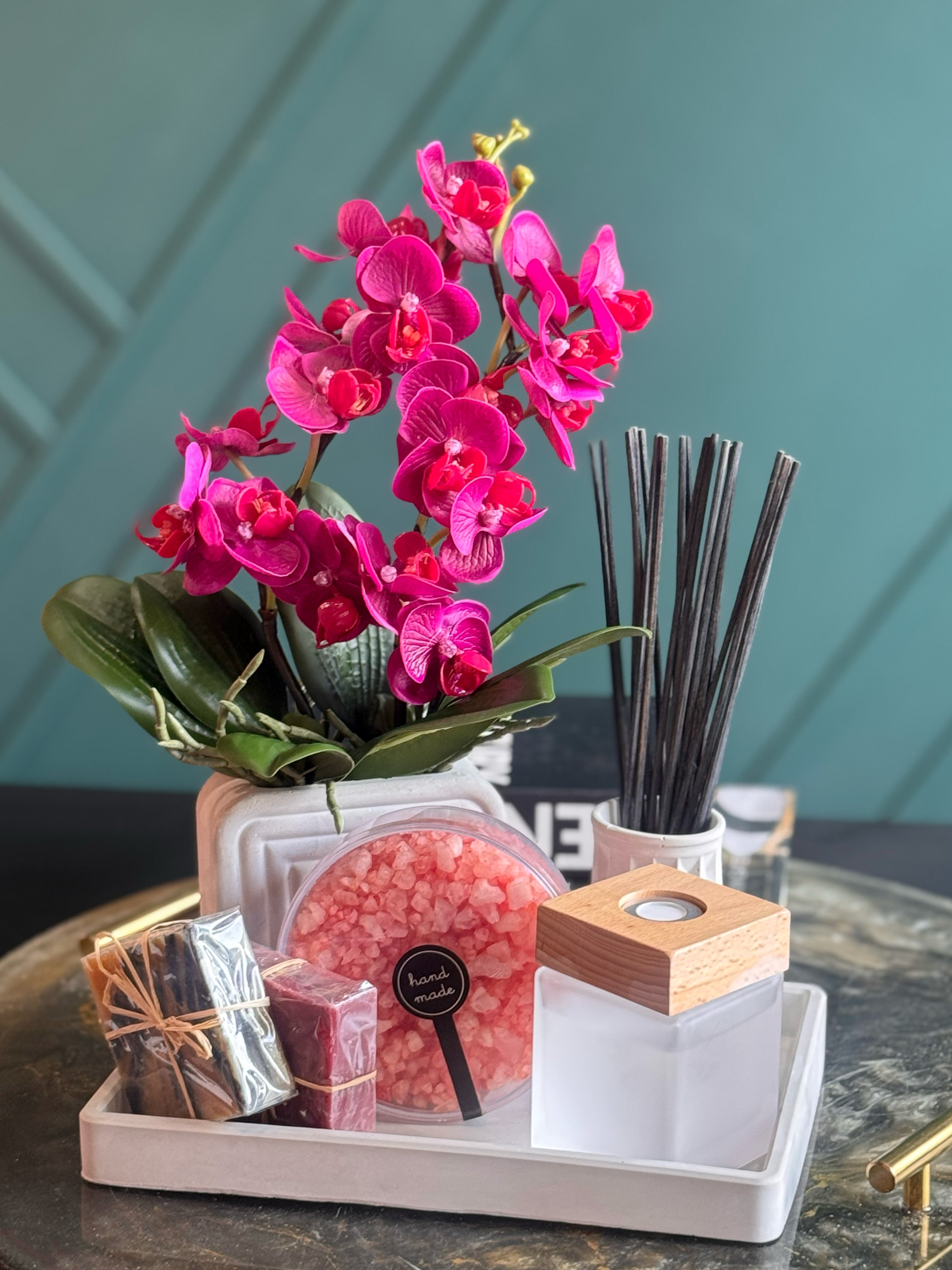 Beautiful orchid spa gift box with handcrafted soap, bath salts and reed diffuser on a decorative tray.
