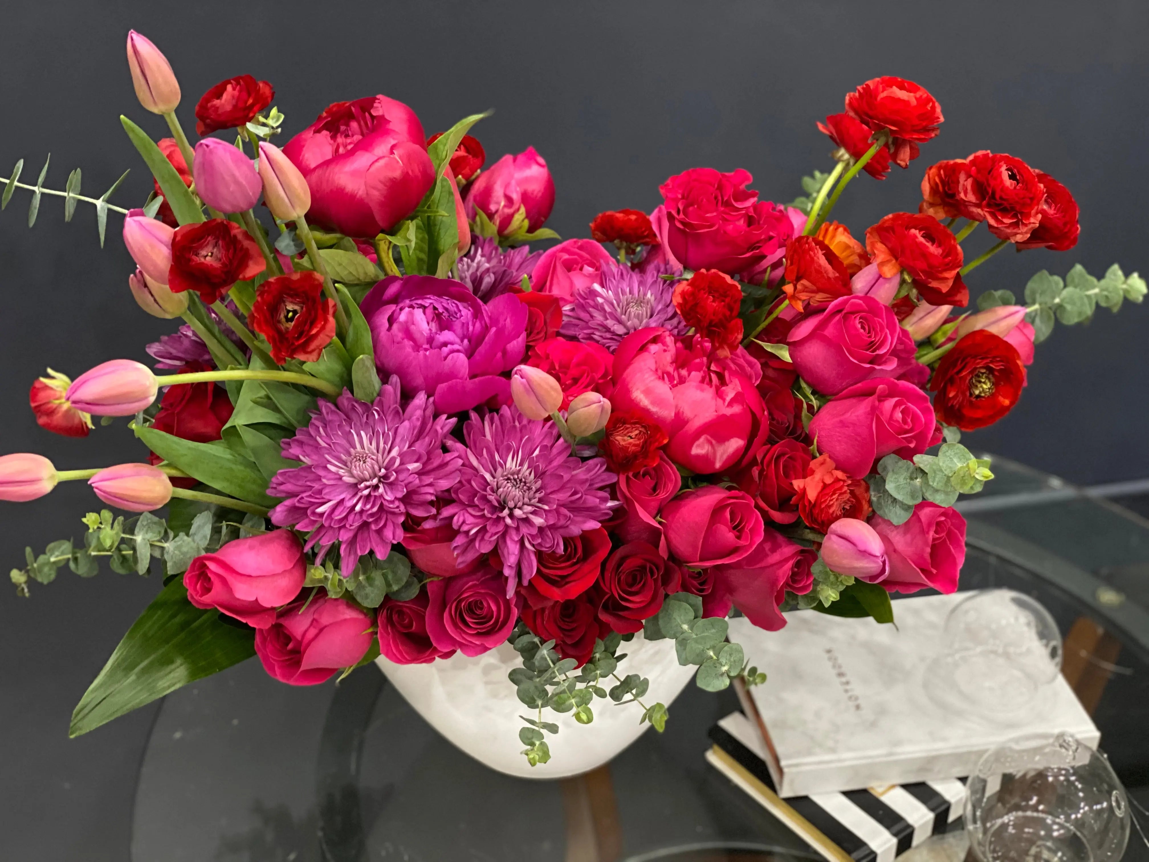 Bouquet of red, pink, and purple flowers in a white vase 