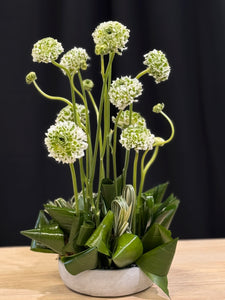 Contemporary floral arrangement with ranunculus and sculptural leaves