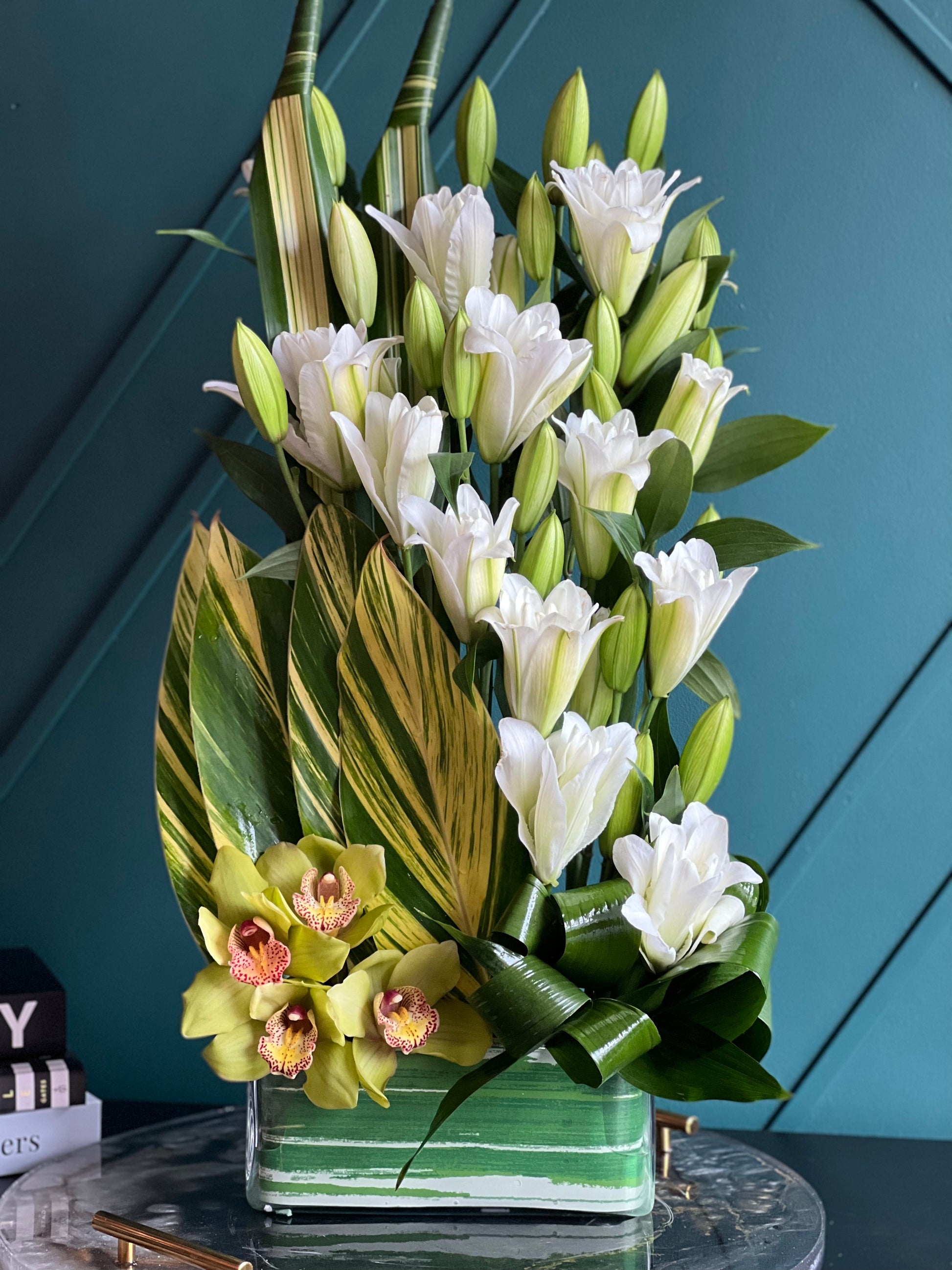 Contemporary tropical flower arrangement with lilies and orchids