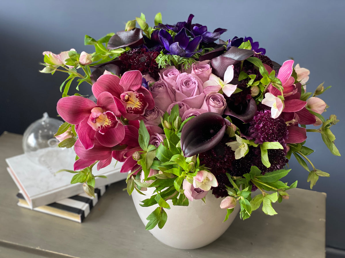Cymbidium orchids and dark purple calla lilies arrangement