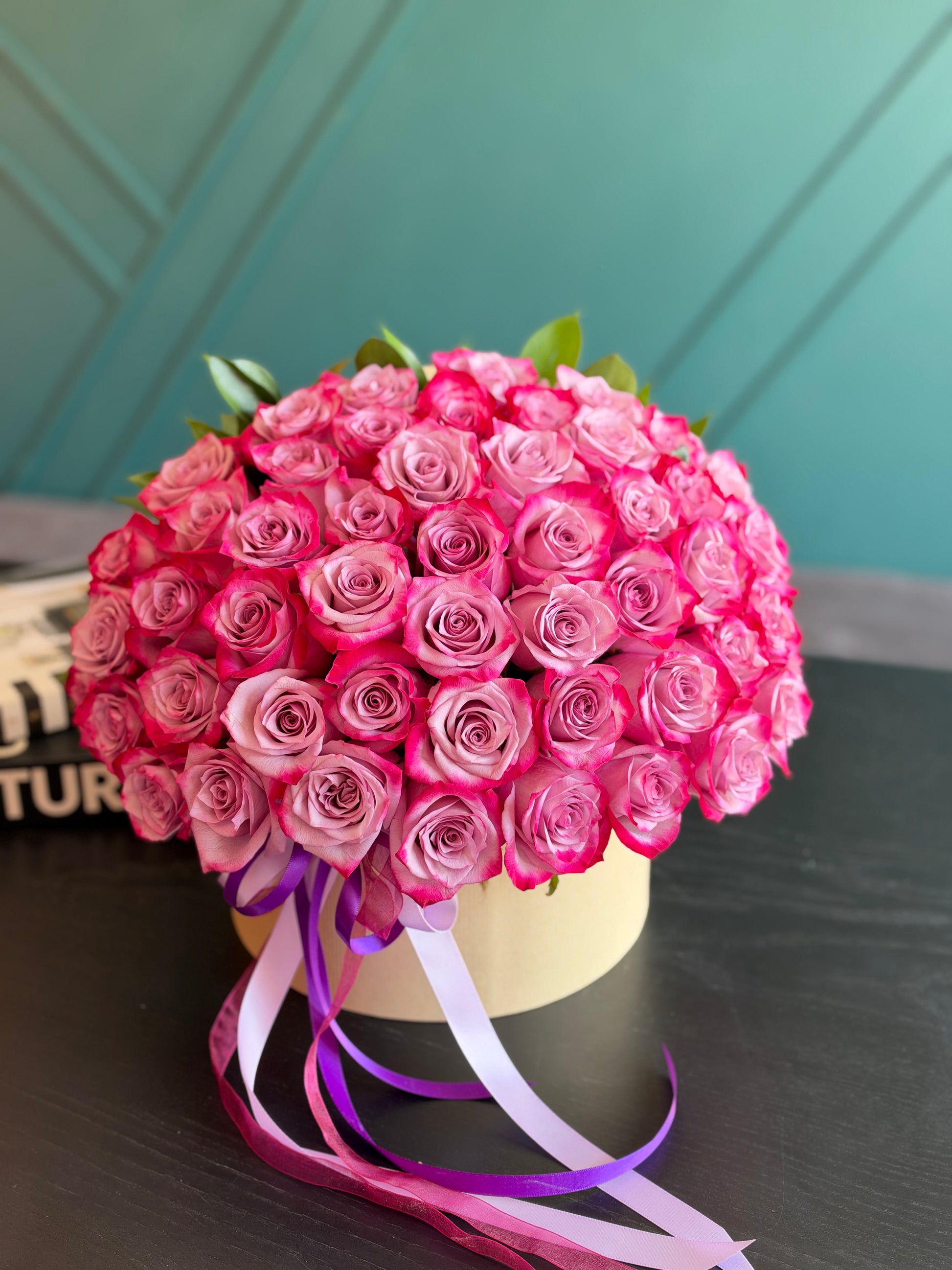 Deep purple roses arranged in a round luxury flower box