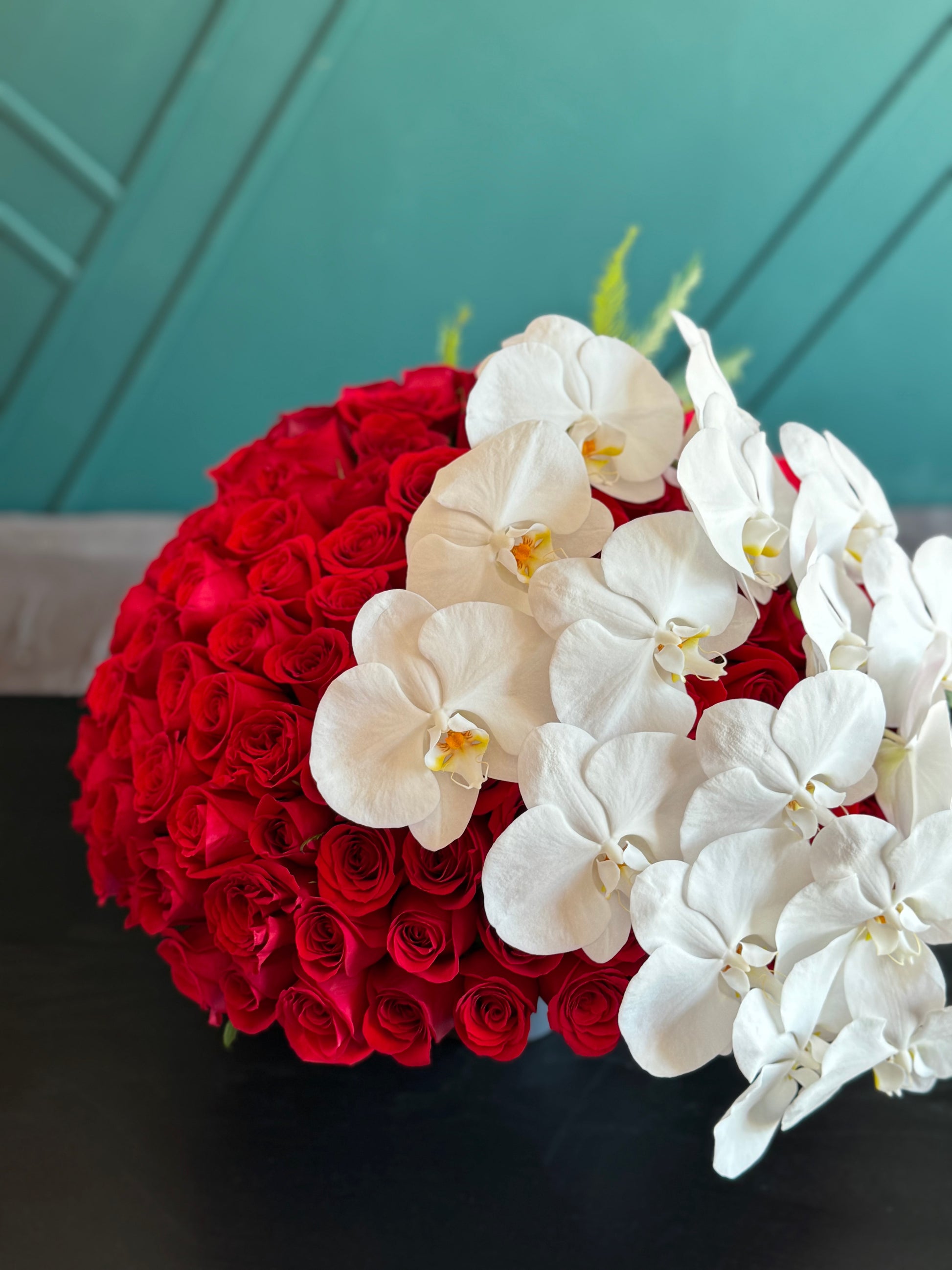 Designer arrangement of red roses and white phalaenopsis orchids