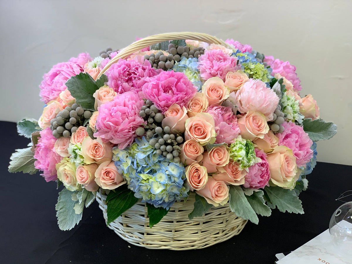 Designer flower basket with peonies roses and blue hydrangeas