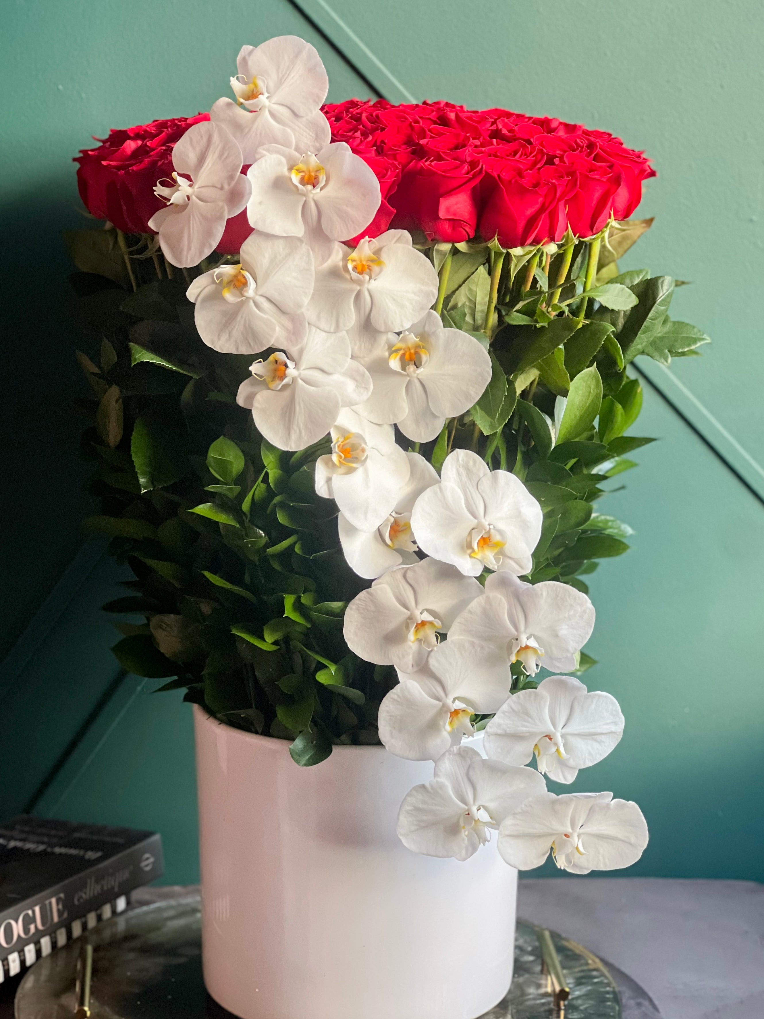 Dramatic 100 red rose arrangement with cascading orchids