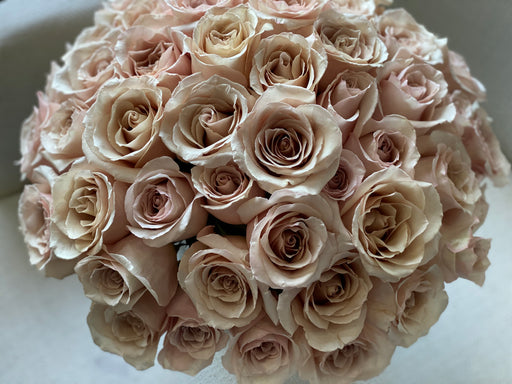 Elegant arrangement of 24 cappuccino roses in a vase by Luxury Flowers Miami