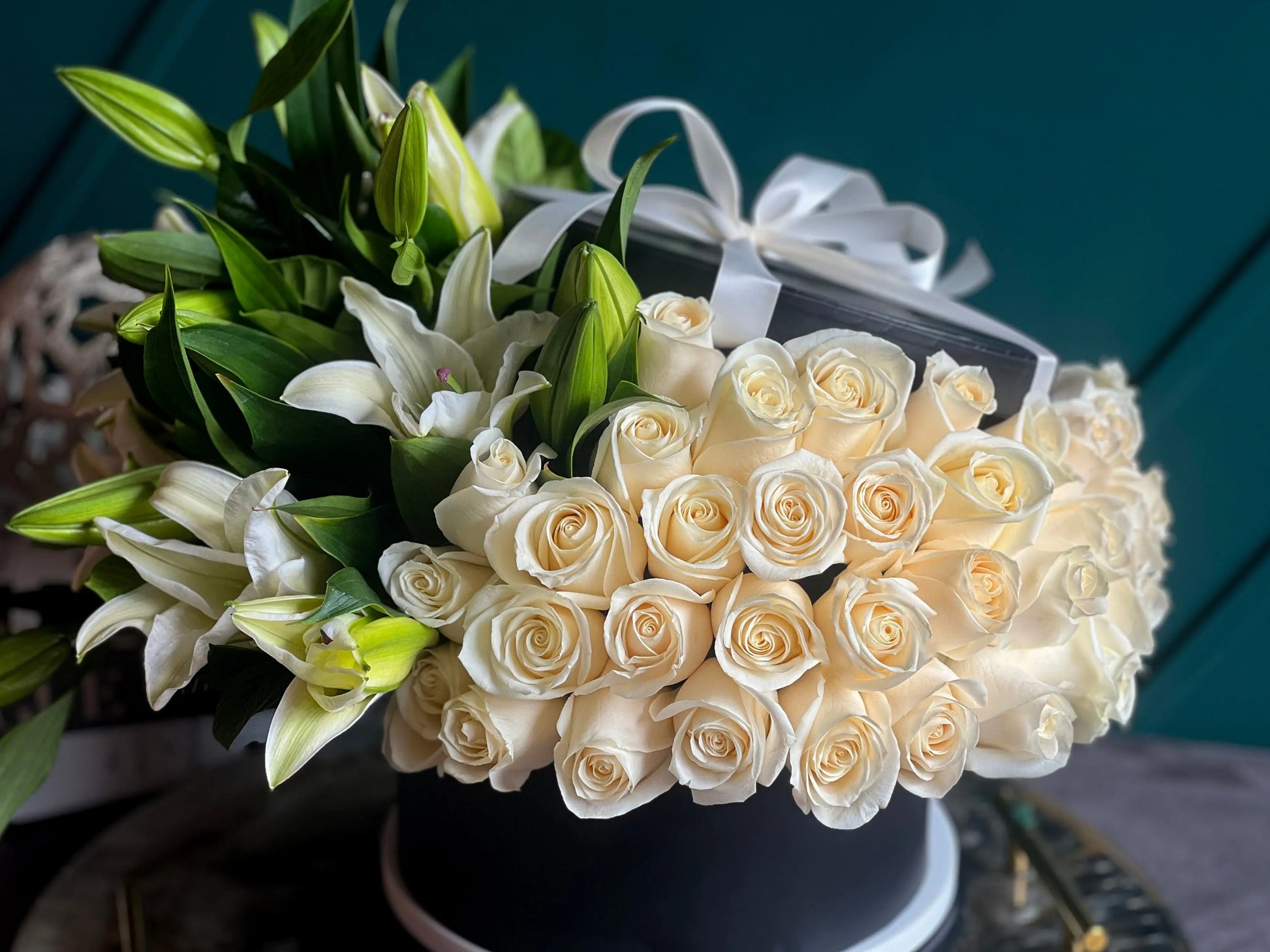 Elegant arrangement of 75 white roses with aromatic lilies in a low black box