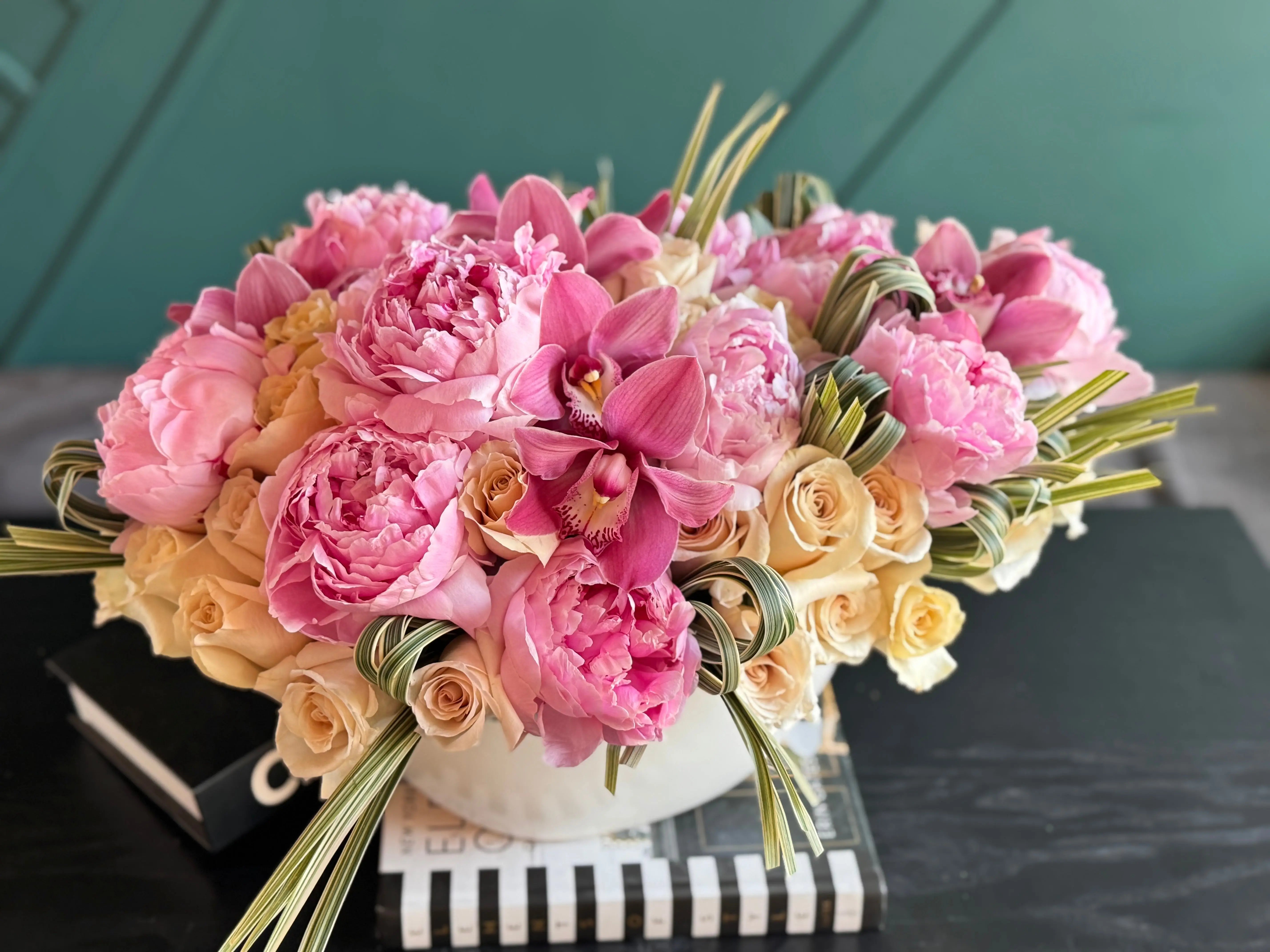 Elegant ceramic vase arrangement with peonies roses orchids and greenery