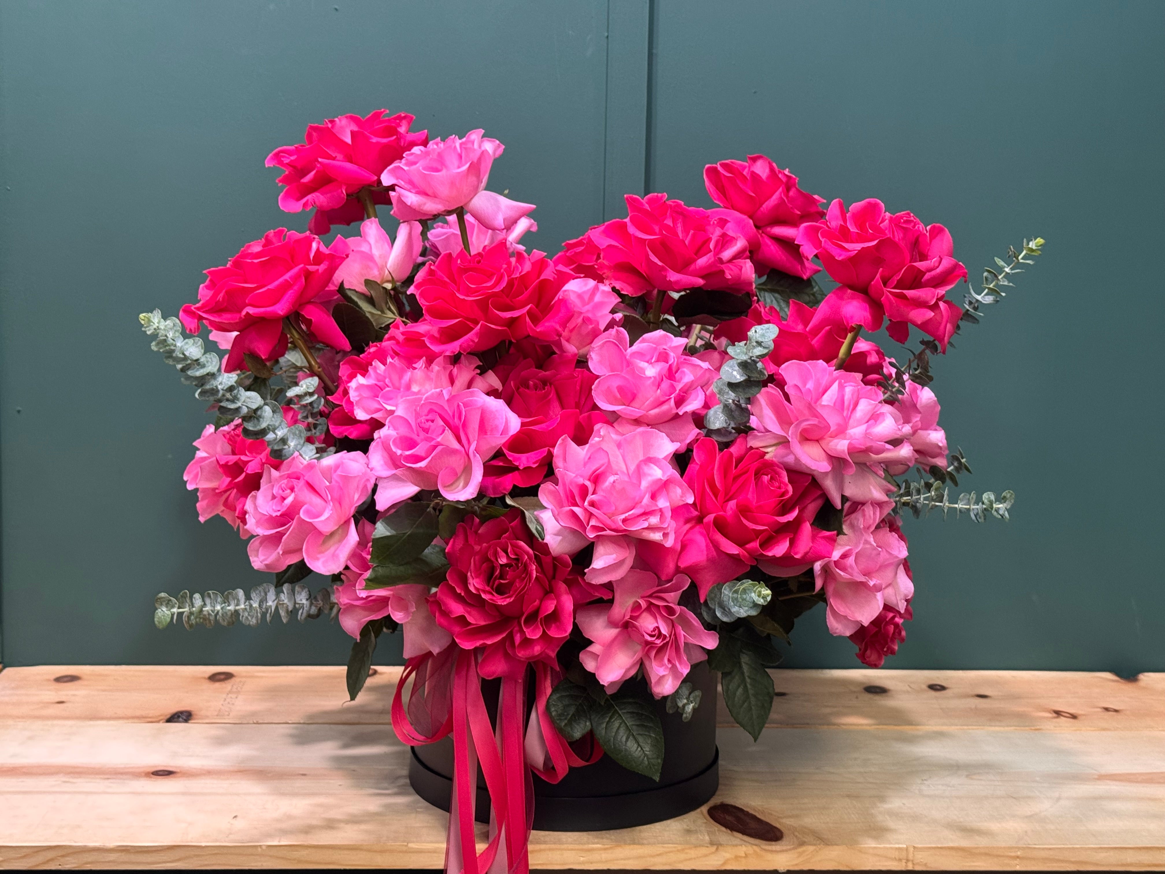 Elegant pink and fuchsia French roses in a modern black floral box