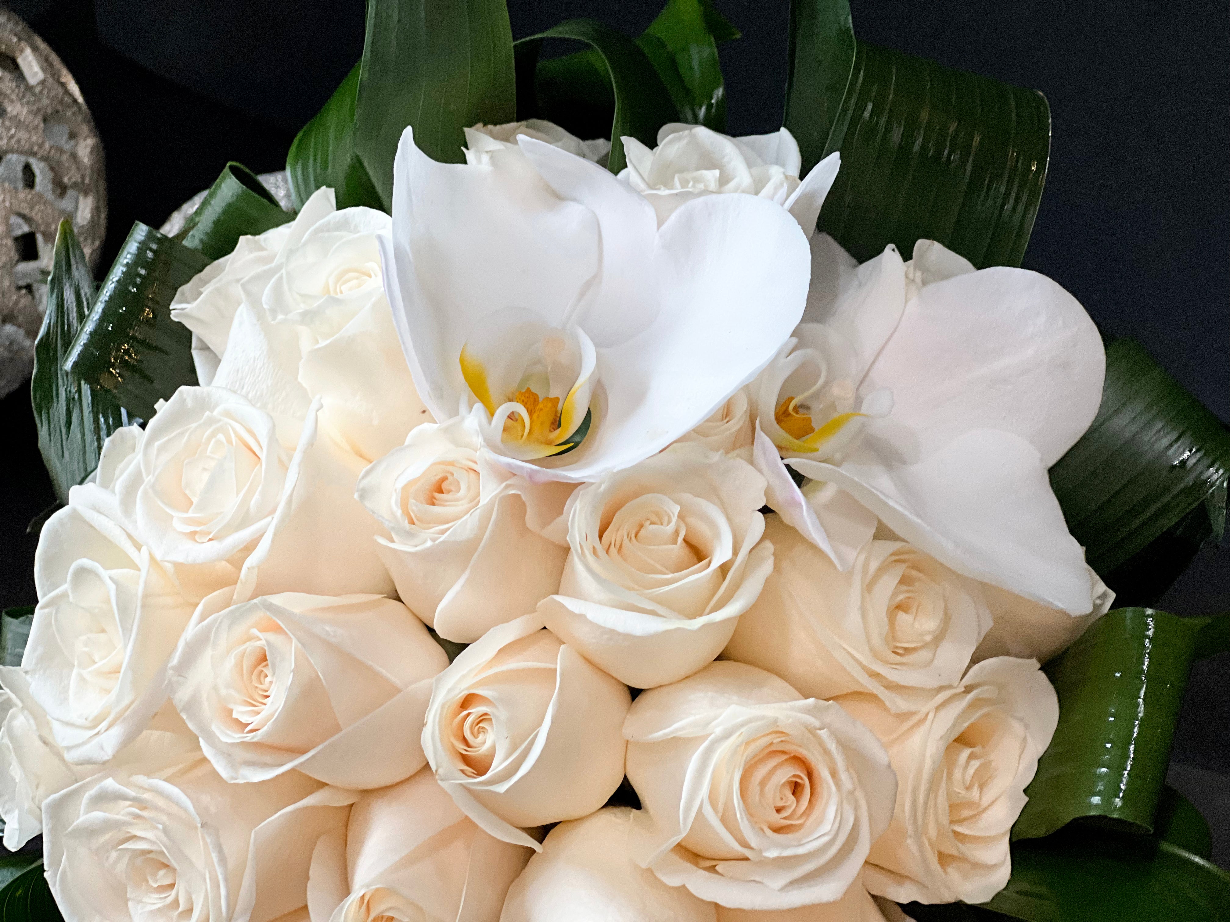 Elegant white roses centerpiece in a glass vase for Miami flower delivery