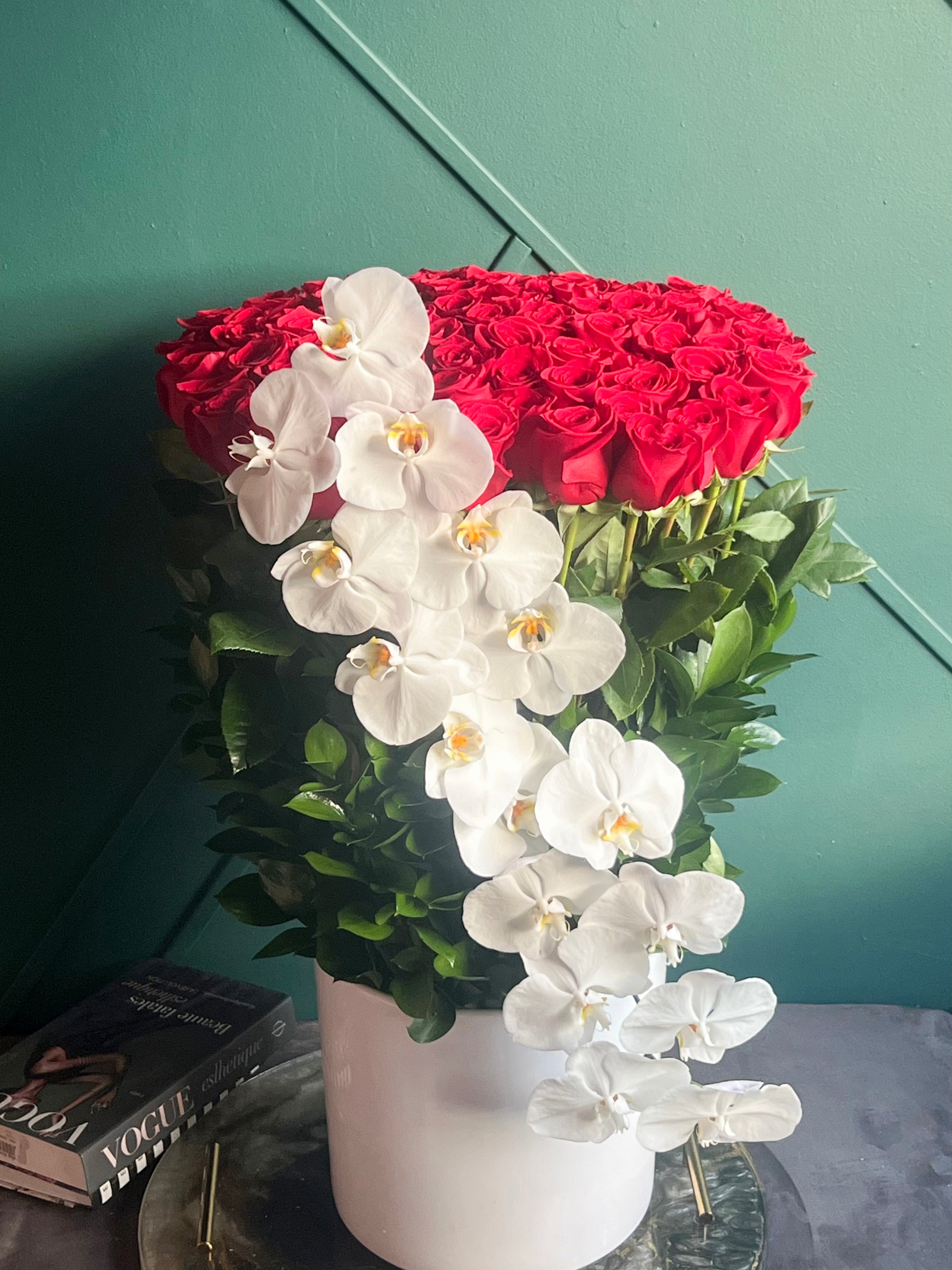 Extra long red roses with cascading white Phalaenopsis orchids