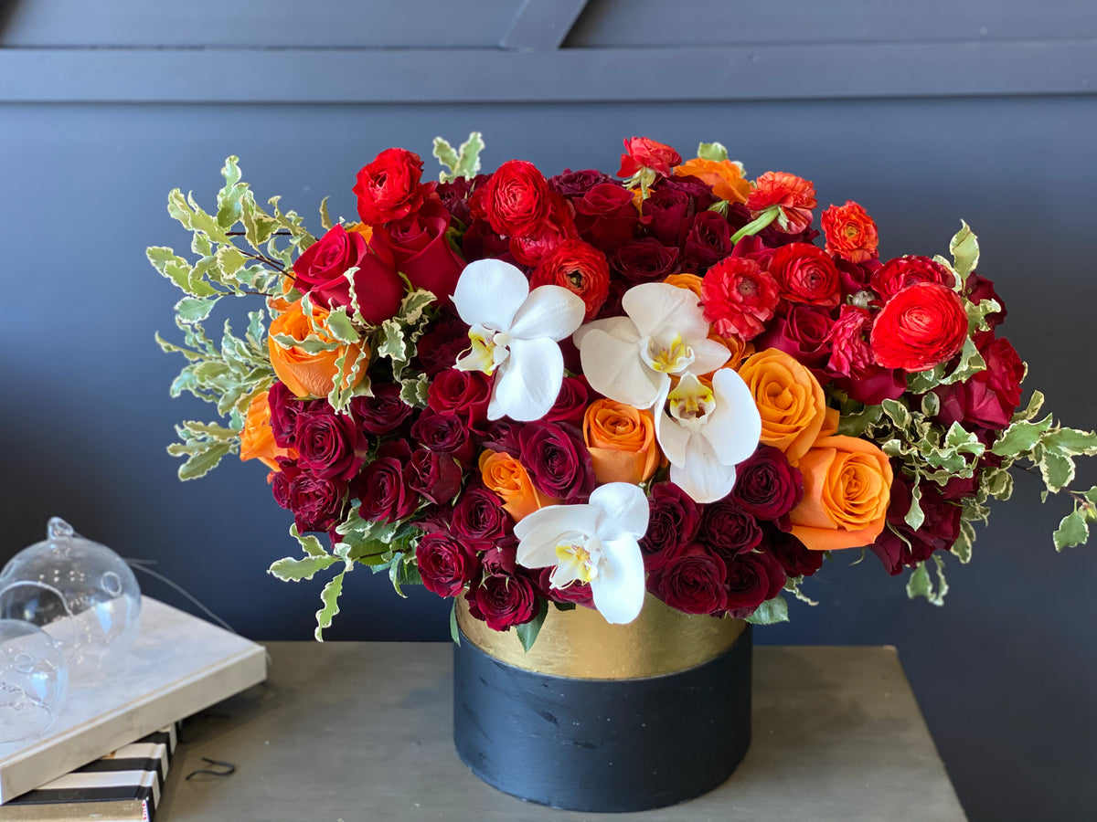 Fall flower arrangement with roses ranunculus and orchids