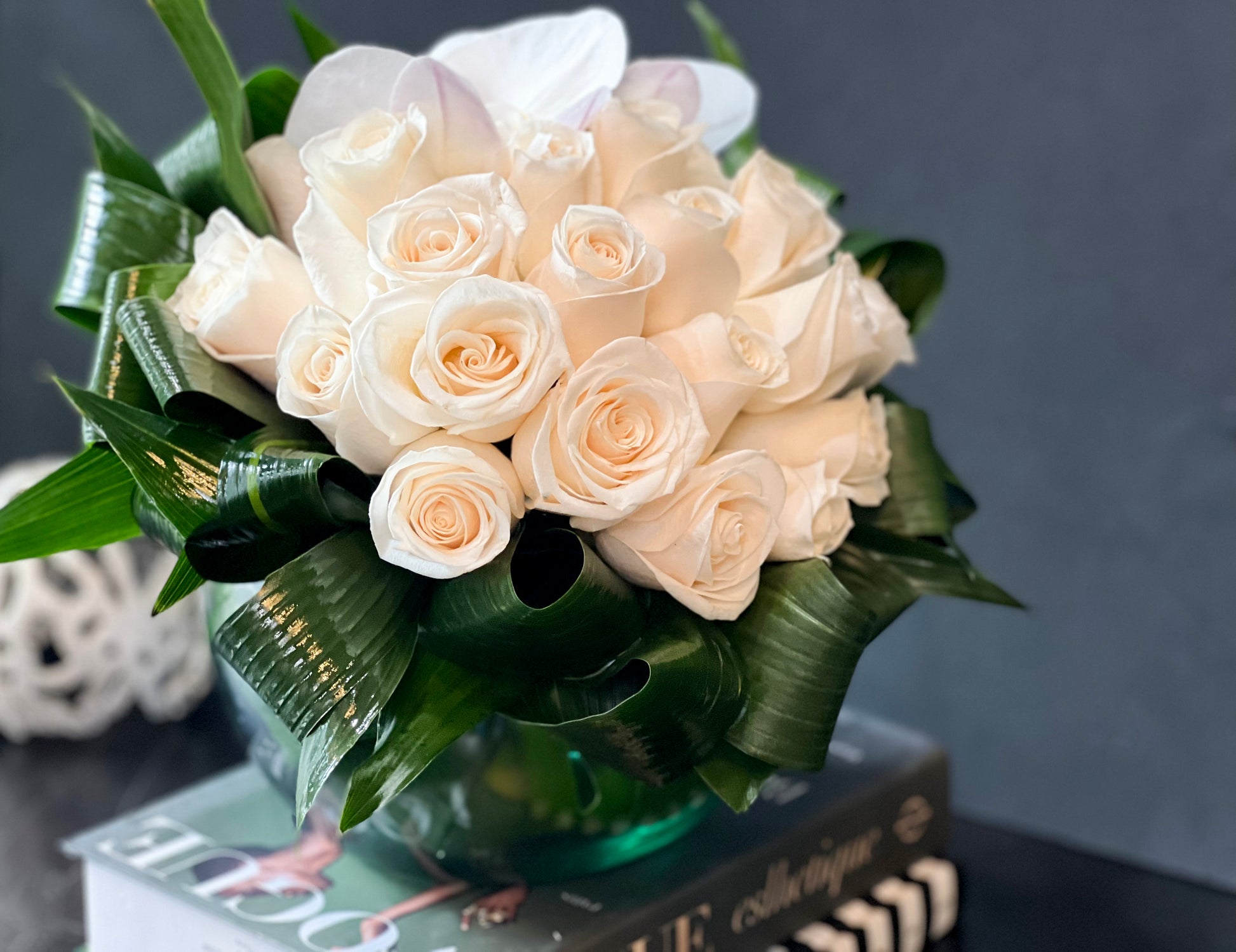 Fresh white roses in a round glass vase for sympathy and elegant gifting