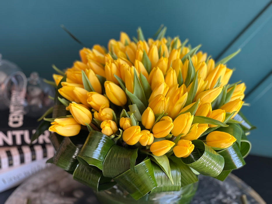100 Yellow Tulips in Clear Vase