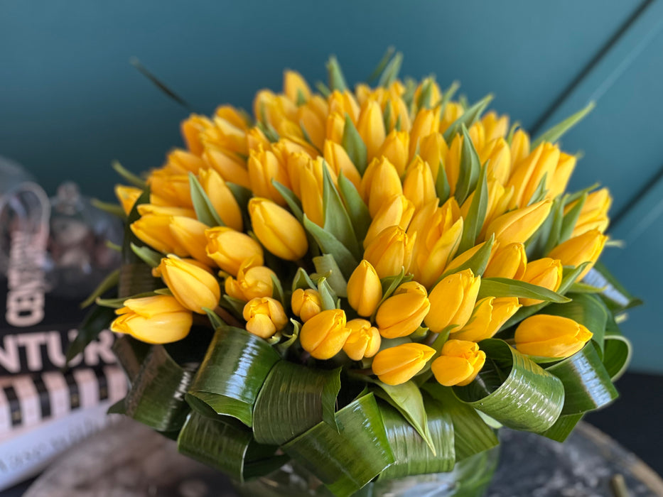 100 Yellow Tulips in Clear Vase