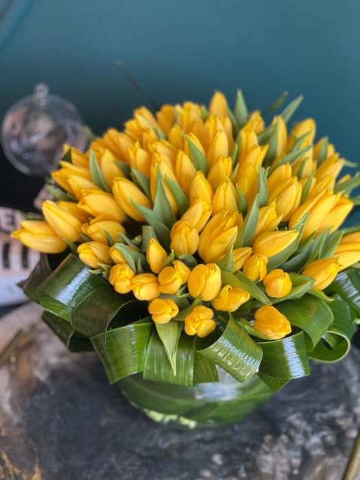 100 Yellow Tulips in Clear Vase