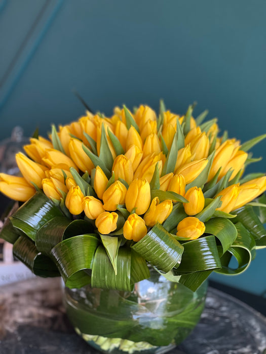 100 Yellow Tulips in Clear Vase
