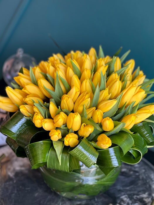 100 Yellow Tulips in Clear Vase
