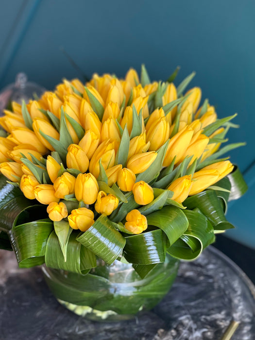 100 Yellow Tulips in Clear Vase