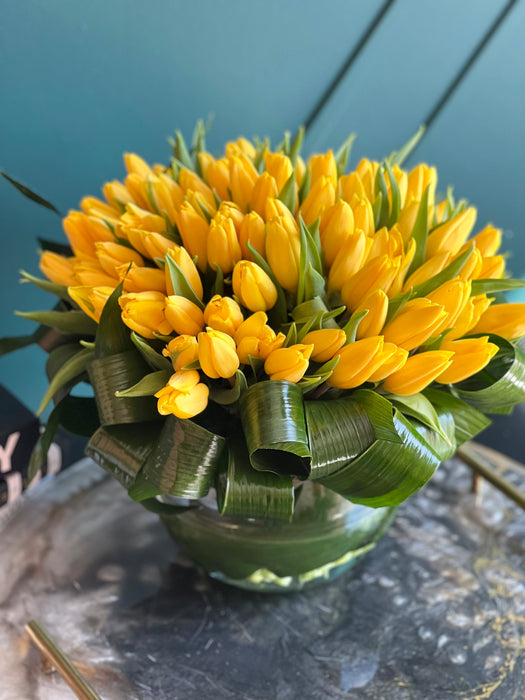 100 Yellow Tulips in Clear Vase