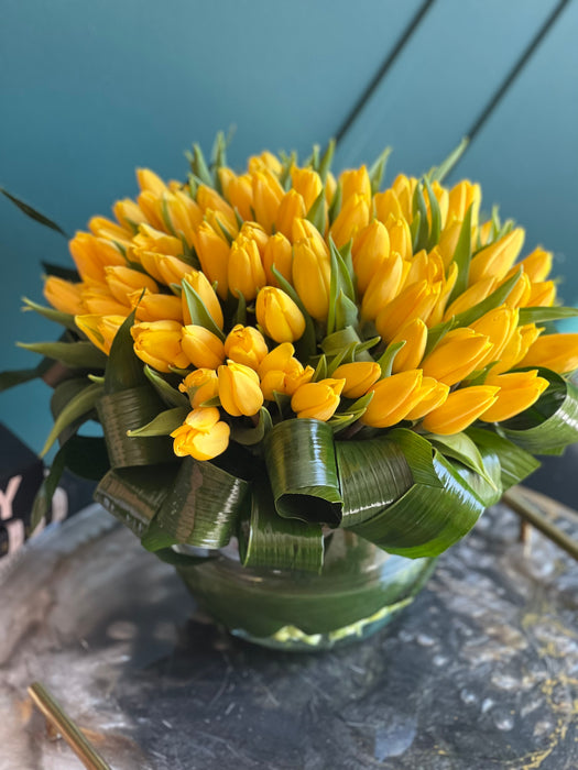 100 Yellow Tulips in Clear Vase