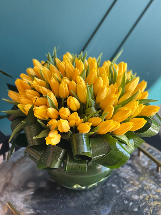 100 Yellow Tulips in Clear Vase