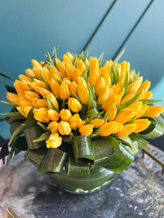 100 Yellow Tulips in Clear Vase