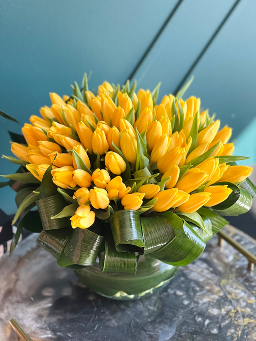 100 Yellow Tulips in Clear Vase