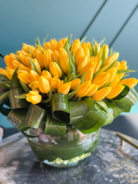 100 Yellow Tulips in Clear Vase