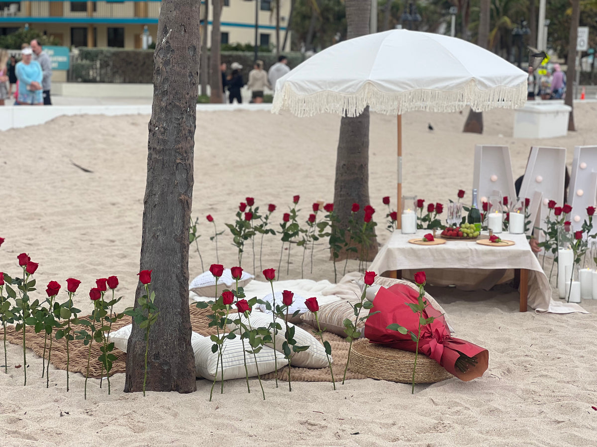 Romantic beach proposal in Miami with roses, candles and Will You Marry Me decor