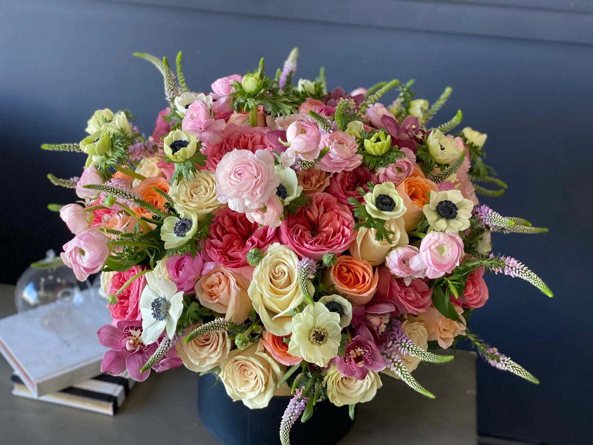 Large floral centerpiece with roses anemones and seasonal blooms