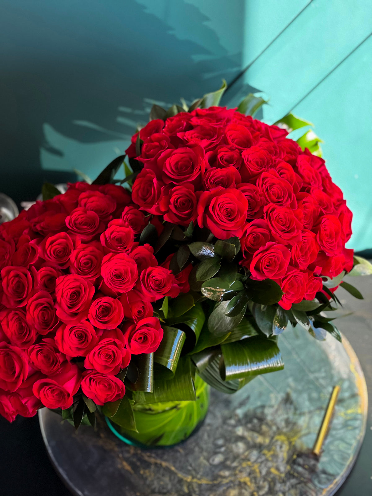 Large red rose arrangement in clear glass vase