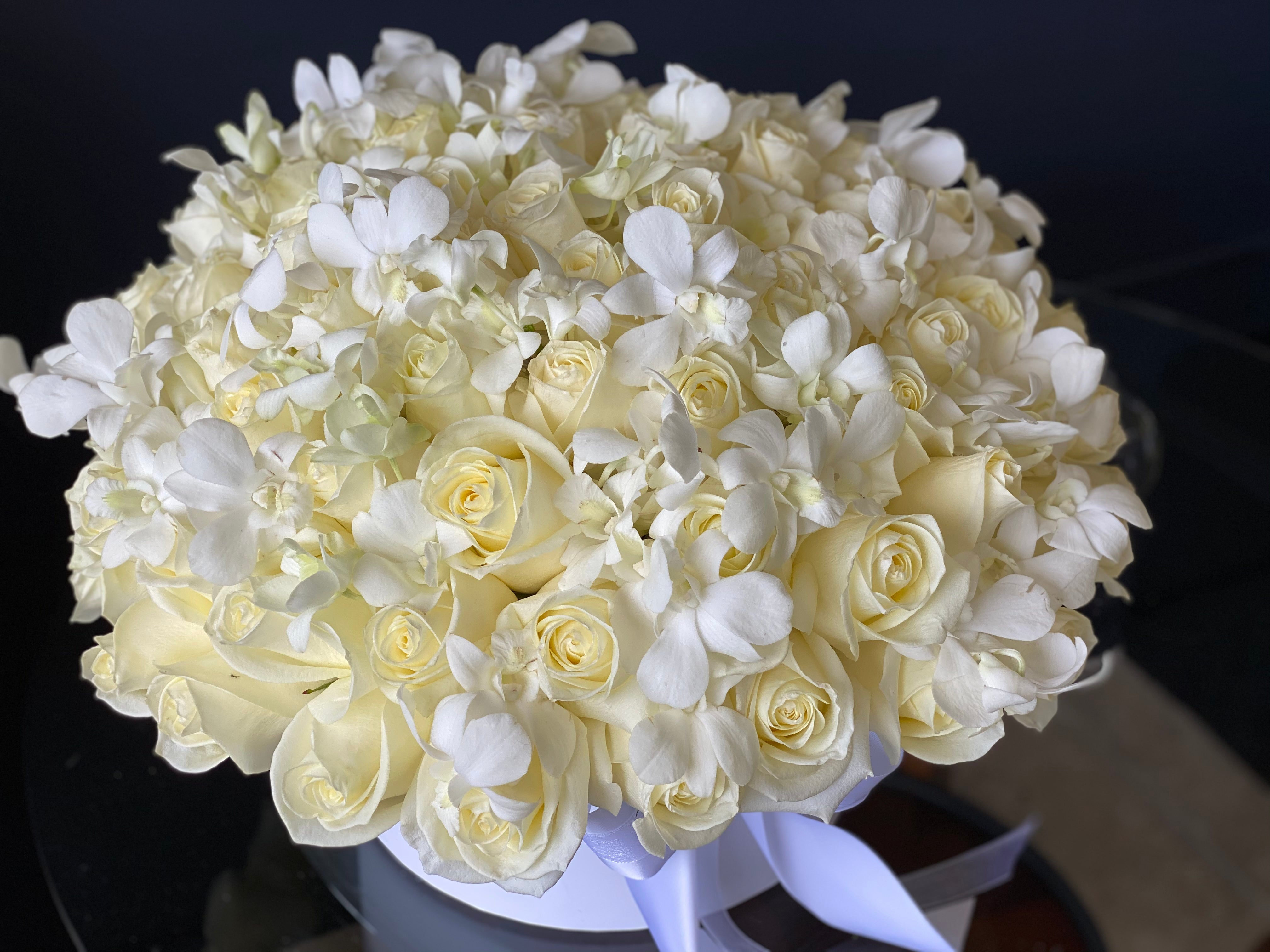 Luxury all-white flower arrangement with roses and orchids