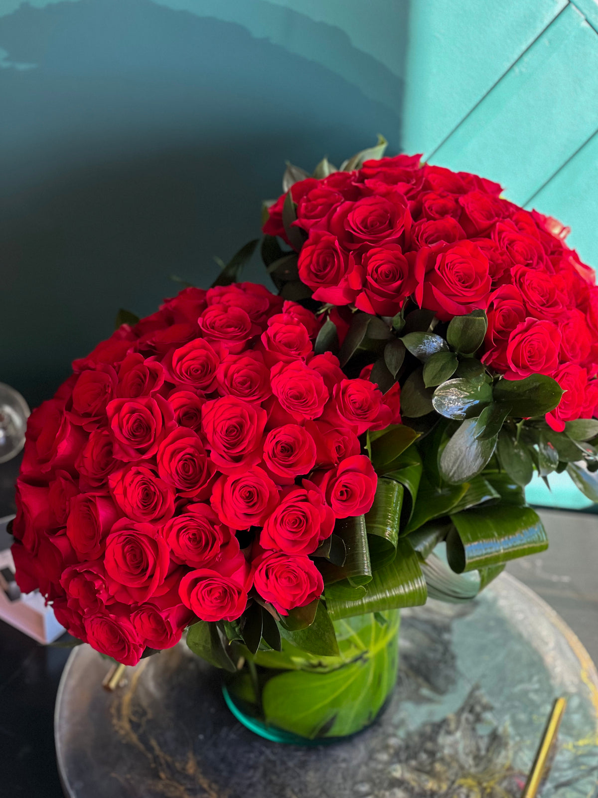 Luxury arrangement of 100 red roses in glass vase
