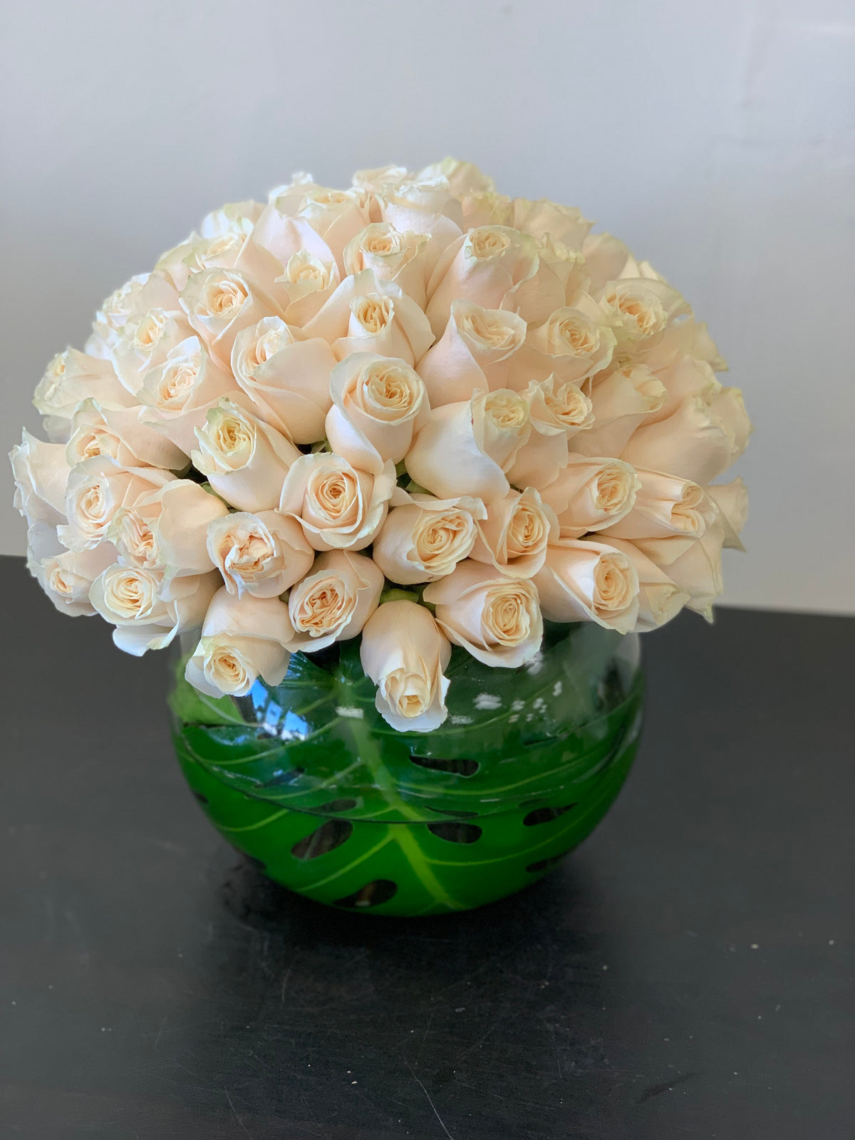 Luxury arrangement of 100 white roses in fishbowl vase